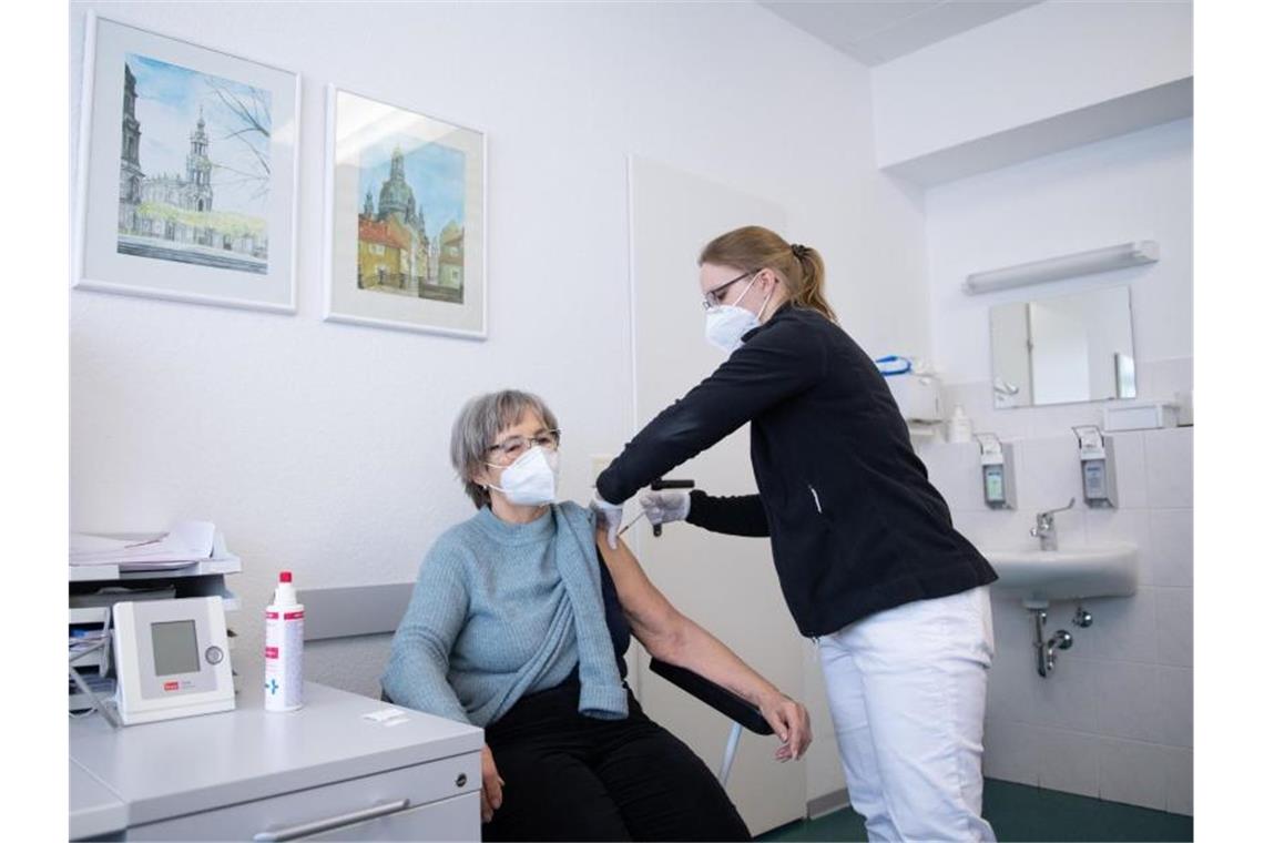 In einer Hausarztpraxis impft eine Hausärztin (r) eine Patientin mit dem Impfstoff von Biontech. Foto: Sebastian Kahnert/dpa/Archivbild