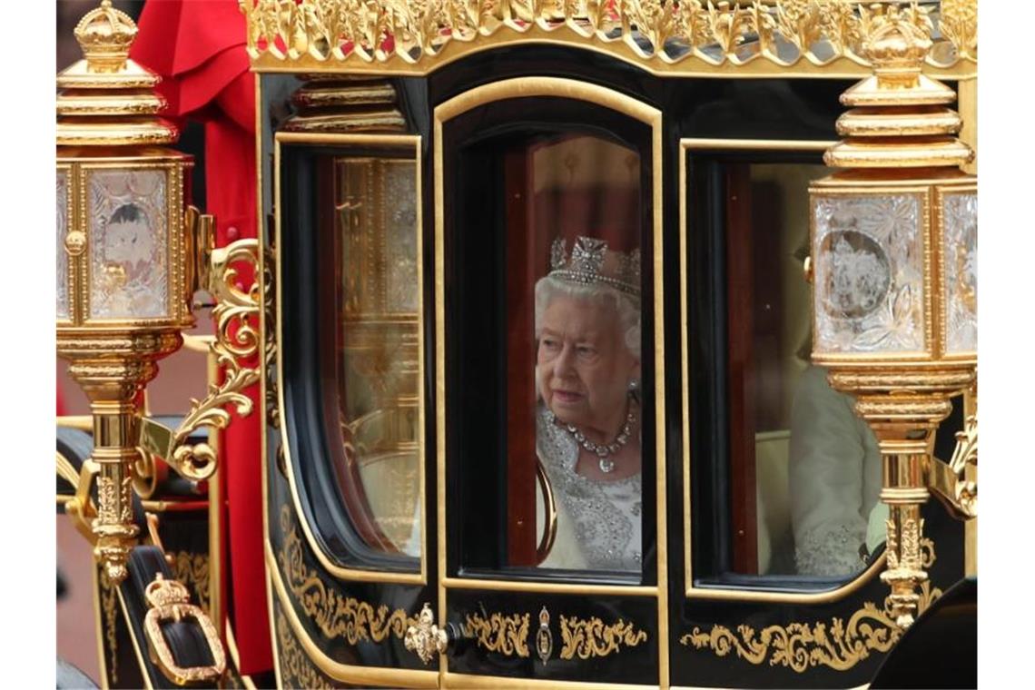 In einer Kutsche fährt Königin Elisabeth II. zur feierlichen Wiedereröffnung des britischen Parlaments. Foto: Yui Mok/PA Wire/dpa
