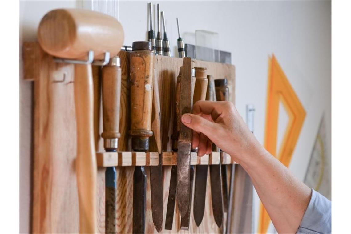 Handwerk: Umsatzverluste für viele Betriebe kaum aufholbar In einer Papierwerkstatt hängen Werkzeuge, die für die Reparatur von Büchern und anderen Schriften benutzt werden. Foto: Jens Kalaene/dpa-Zentralbild/dpa
