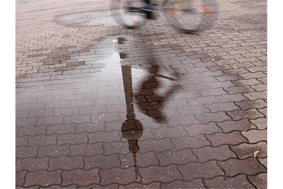 In einer Regenpfütze in Berlin spiegelt sich der Fernsehturm. . Foto: Jörg Carstensen/dpa