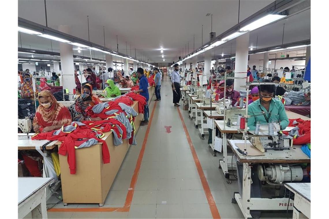 In einer Textilfabrik im bangladeschischen Savar sitzen Näherinnen und Näher bei der Arbeit. Foto: Nick Kaiser