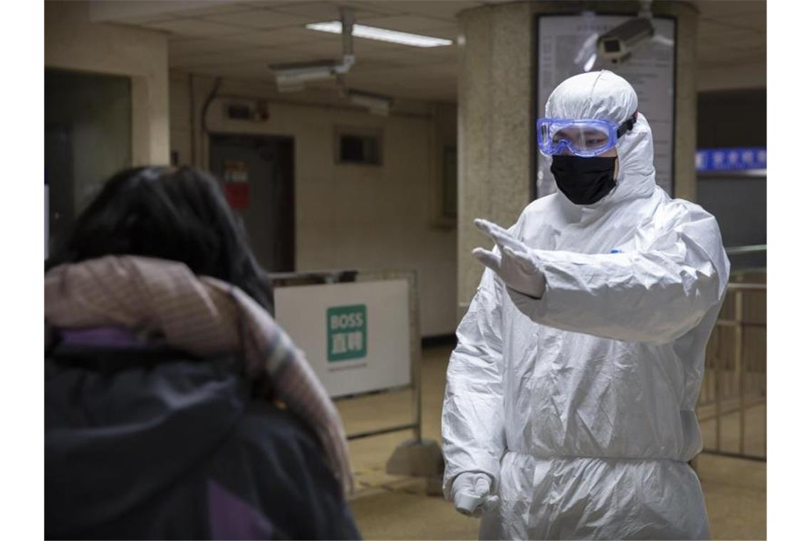 In einer U-Bahn-Station in Peking müssen Fahrgäste an Kontrollschleusen ihre Körpertemperatur messen lassen. Foto: Mark Schiefelbein/AP/dpa