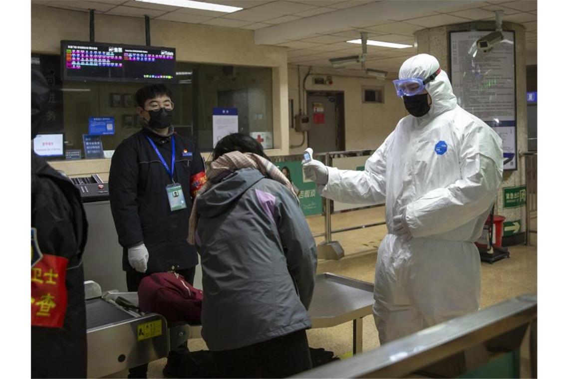 In einer U-Bahn-Station in Peking müssen Fahrgäste ihre Körpertemperatur messen lassen. Foto: Mark Schiefelbein/AP/dpa