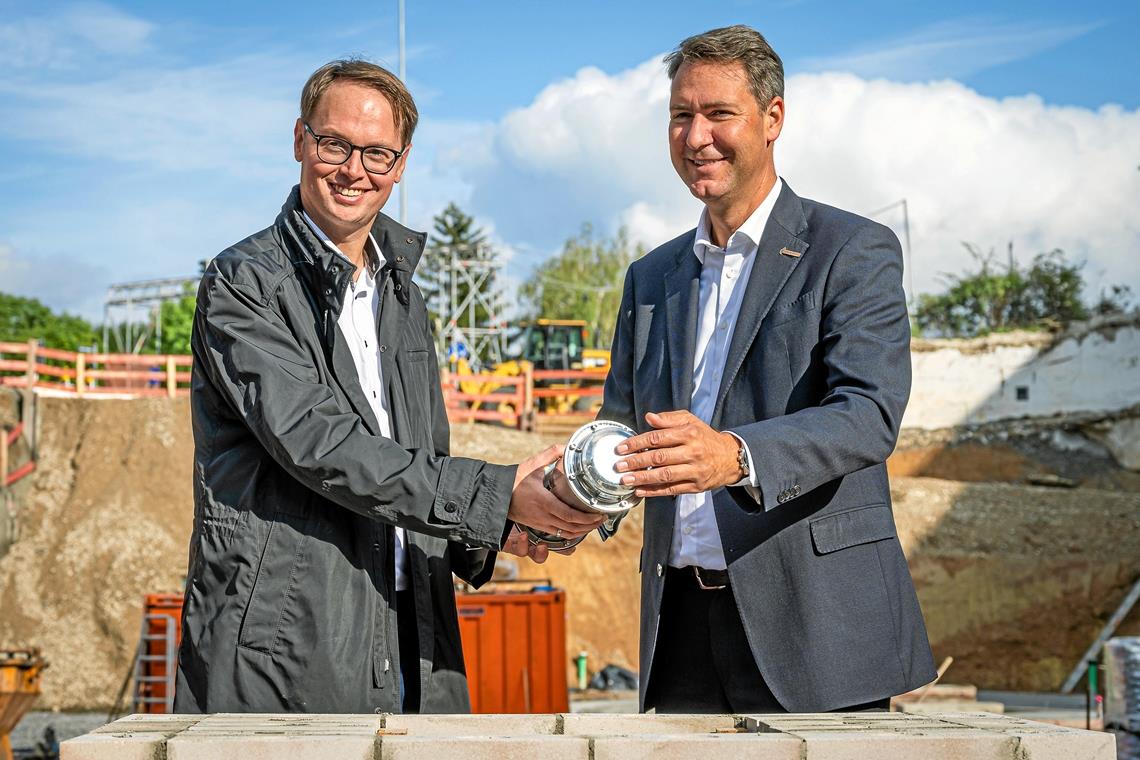 In einer Zeitkapsel haben Waiblingens OB Sebastian Wolf (links) und Landrat Richard Sigel zur Grundsteinlegung neben aktuellen Tageszeitungen auch eine Urkunde sowie Baupläne und Fotos versenkt. Foto: Heiko Potthoff