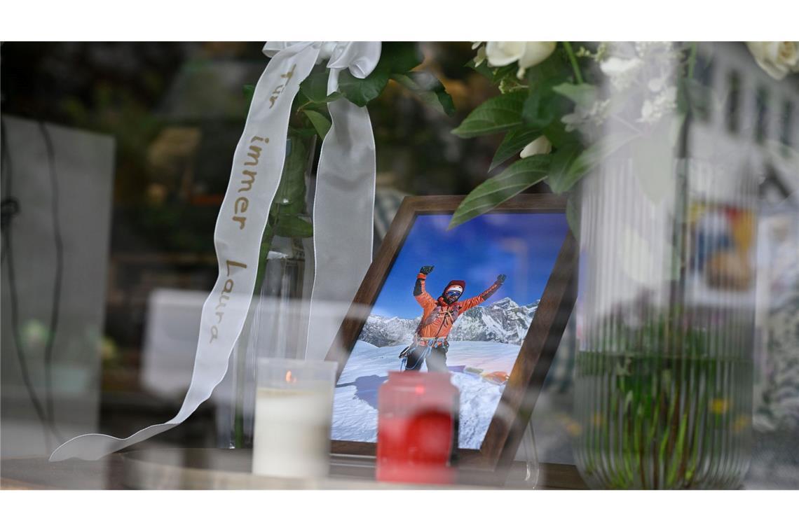 in Foto, Kerzen, Rosen und eine Schleife mit der Aufschrift "Für immer Laura" stehen im Einrichtungsgeschäft Dahlmeier im Schaufenster.