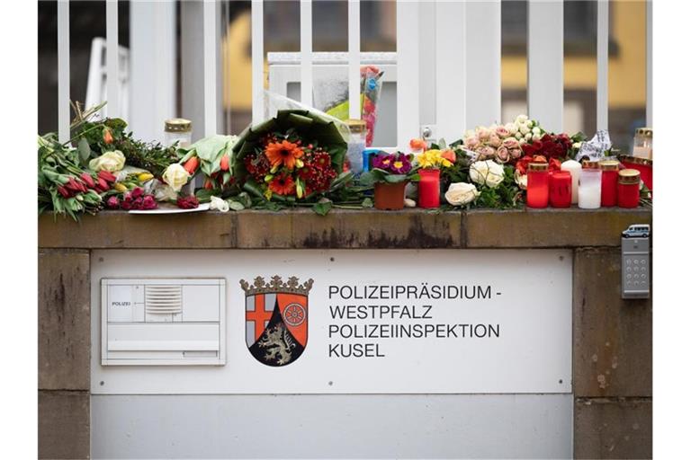 In Gedenken an die ermordeten Beamten: Passanten haben Blumen und Kerzen vor der Polizeiinspektion Kusel gelegt. Foto: Sebastian Gollnow/dpa