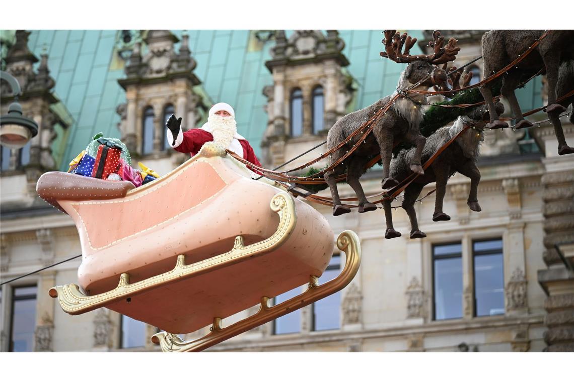 Glühwein bei bis zu 20 Grad: Viele Weihnachtsmärkte eröffnet In Hamburg flog der Weihnachtsmann in einem Rentierschlitten über den Markt vor dem Rathaus.