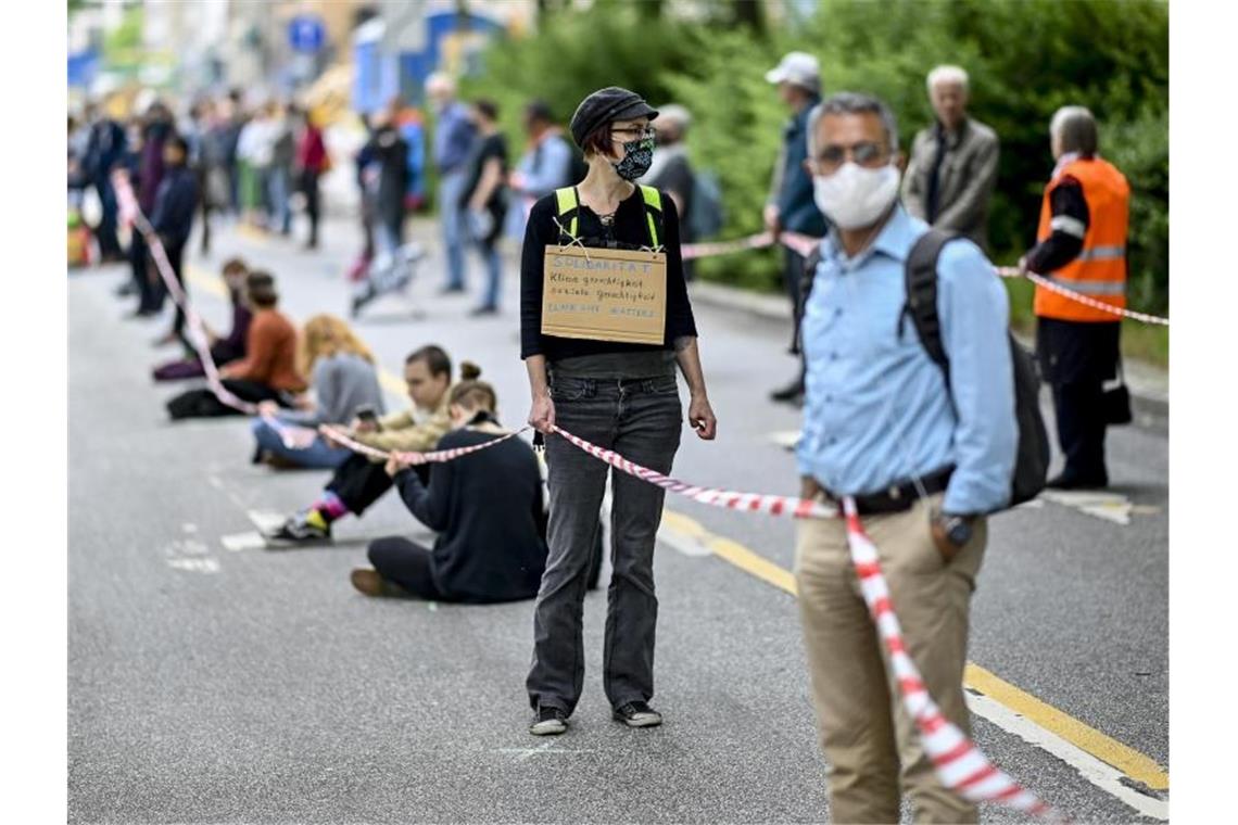 In Hamburg zieht sich eine Menschenkette vom Rathaus zum Hauptbahnhof. Foto: Axel Heimken/dpa