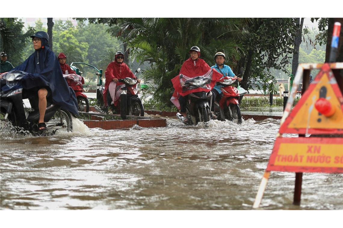 Taifun "Kajiki": Mehrere Tote in Vietnam und Thailand In Hanoi bahnten sich viele Motorradfahrer ihren Weg durch die Wassermassen.