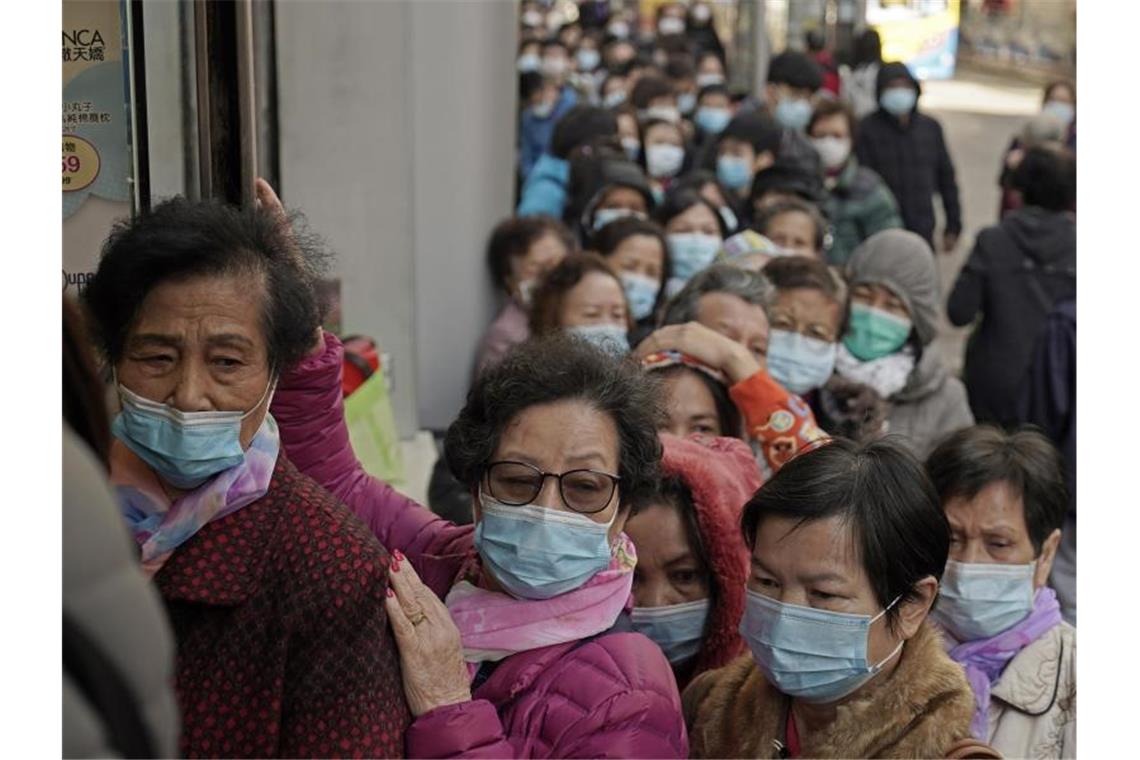 In Hongkong stehen Menschen Schlange, um Mundschutzmasken zu kaufen. Foto: Kin Cheung/AP/dpa