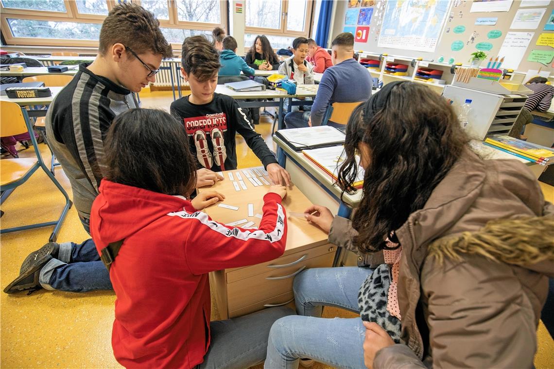 In kleineren Gruppen arbeiten die Schüler an Aufgaben. Hier bringen sie die Steigerungsformen einzelner Adjektive in die richtige Reihenfolge.