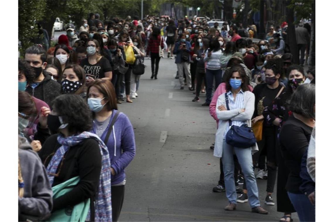 In langen Schlangen stehen die Menschen in Chiles Hauptstadt an, um ihre Stimmen abzugeben. Foto: Esteban Felix/AP/dpa