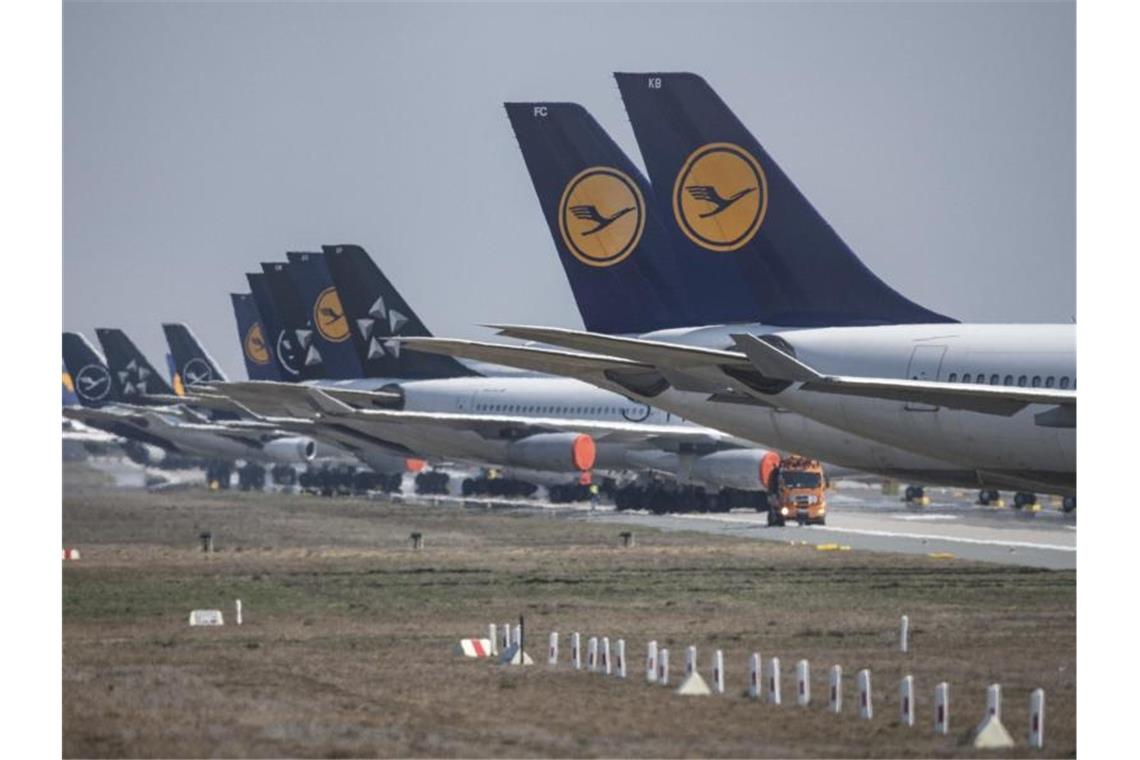 Lufthansa kann sich nicht aus eigener Kraft retten In langer Reihe stehen auf einer Landebahn des Flughafens Frankfurt Maschinen der Lufthansa, die wegen der weltweiten Corona-Pandemie derzeit außer Dienst gestellt sind. Foto: Boris Roessler/dpa