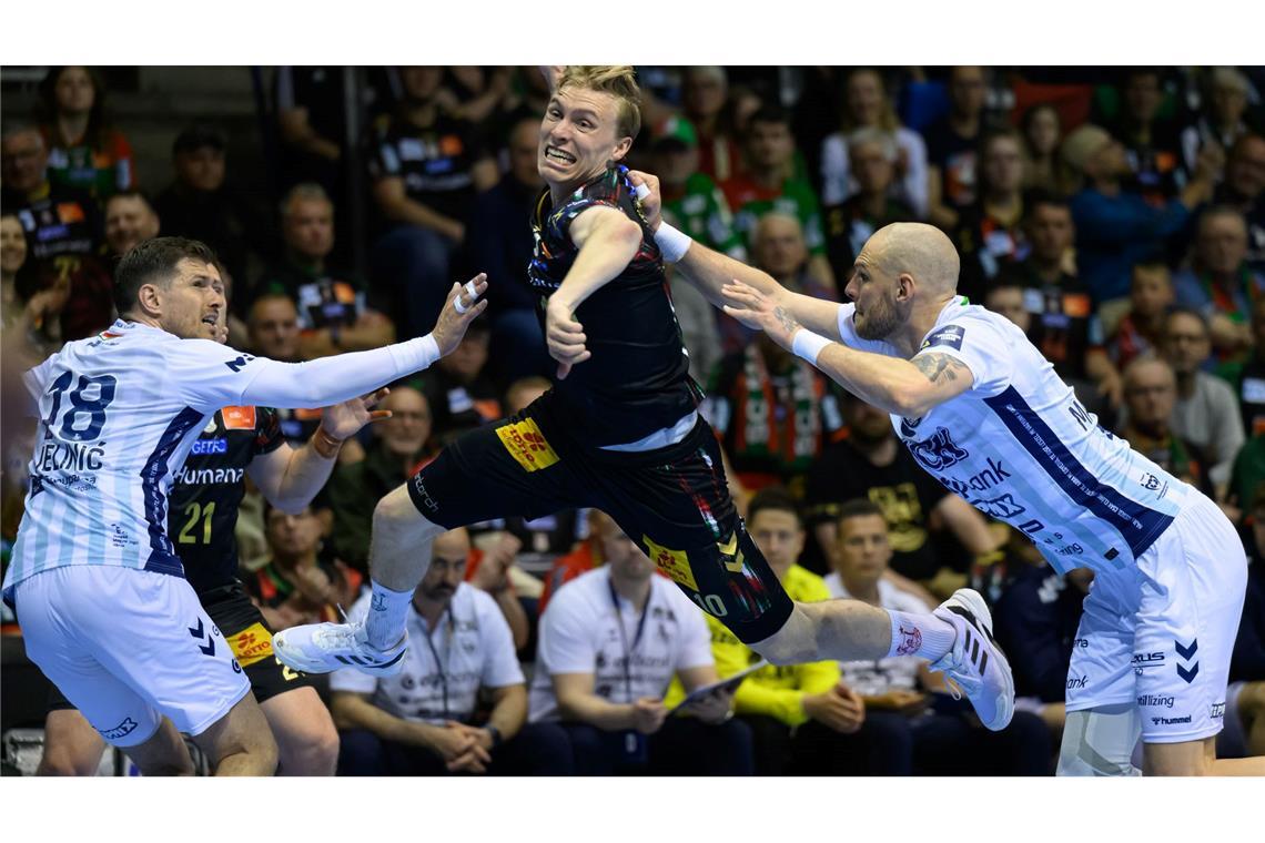 In Magdeburg wird Gisli Kristjansson (SC Magdeburg, M) von Marin Jelinic (SC Pick Szeged, l) und Borut Mackovsek (SC Pick Szeged) angegriffen.