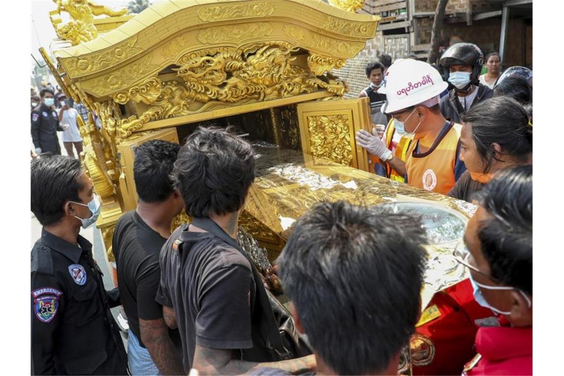 In Mandalay wird der Sarg eines Demonstranten in einen Leichenwagen geschoben. Der Mann war am Samstag von Sicherheitskräften erschossen worden. Foto: Uncredited/AP/dpa