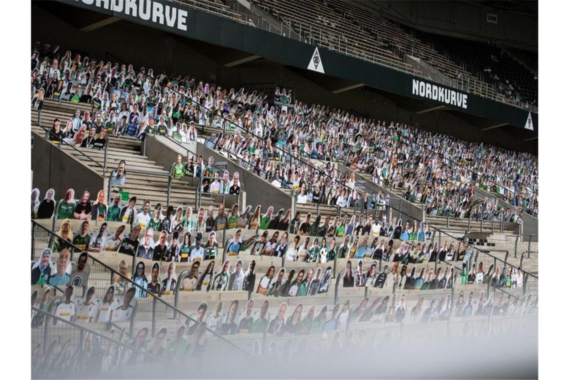 Am Tropf der Lockerungen: Bundesliga vor größter Hürde In Mönchengladbach sind im Borussia-Park bereits Pappaufsteller von Fans für mögliche Geisterspiele aufgestellt. Foto: Marius Becker/dpa