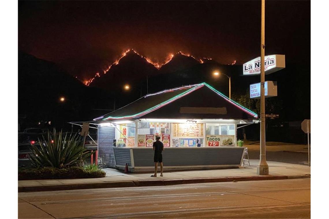 Verheerende Brände an US-Westküste erreichen Rekord-Ausmaße In Monrovia in Kalifornien lodern die Waldbrände in den Hügeln, im Vordergrund ein Fast-Food-Restaurant. Foto: David Swanson/ZUMA Wire/dpa