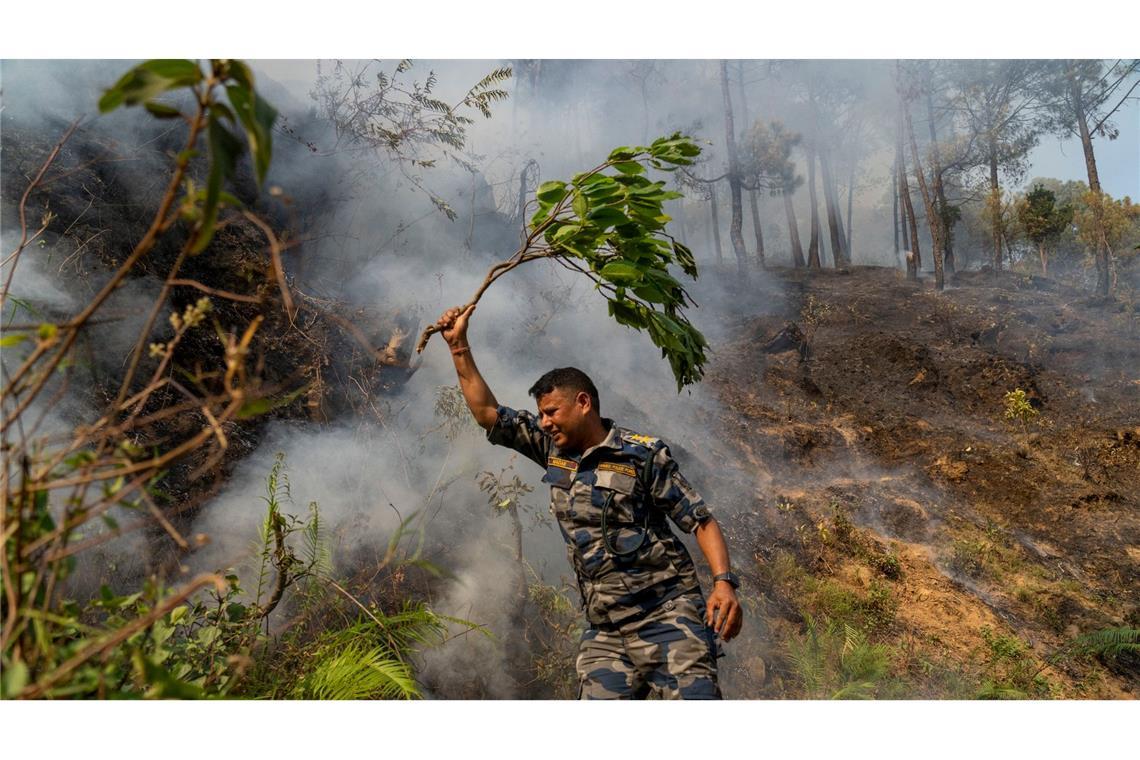 In Nepal ist ein Waldbrand im Shivapuri-Nationalpark am Rande von Lalitpur ausgebrochen. Seitdem wird versucht, das Feuer zu löschen, wie durch diesen Polizisten.