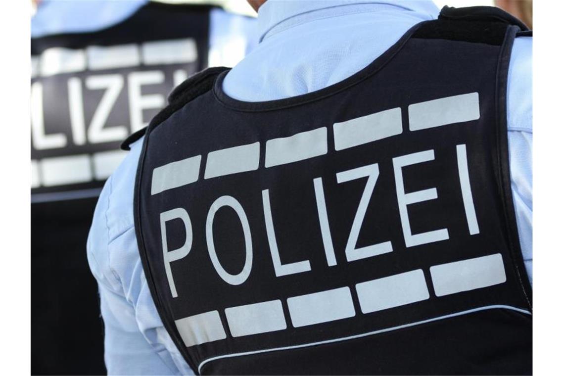 In Polizei-Westen gekleidete Polizisten stehen am Straßenrand. Foto: Silas Stein/Archivbild