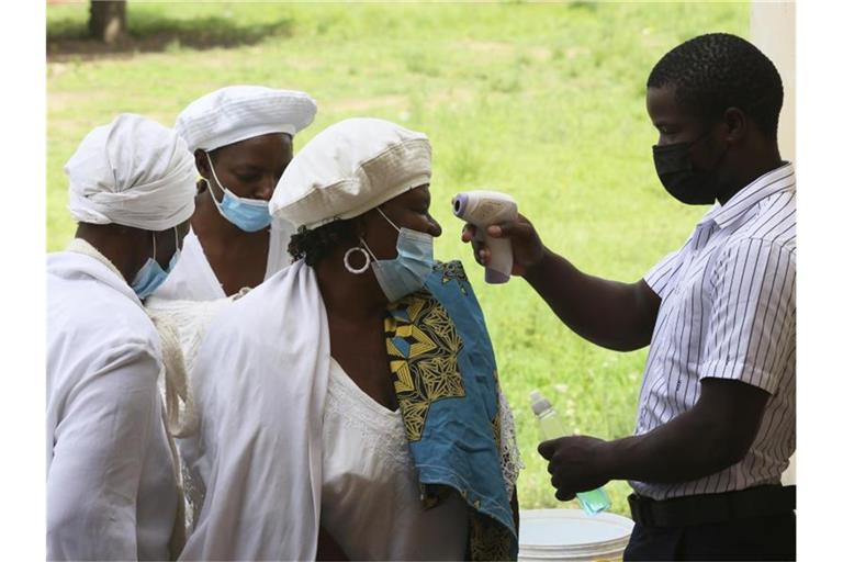 In Simbabwes Hauptstadt Harare lassen Menschen ihre Temperatur überprüfen. Foto: Tsvangirayi Mukwazhi/AP/dpa