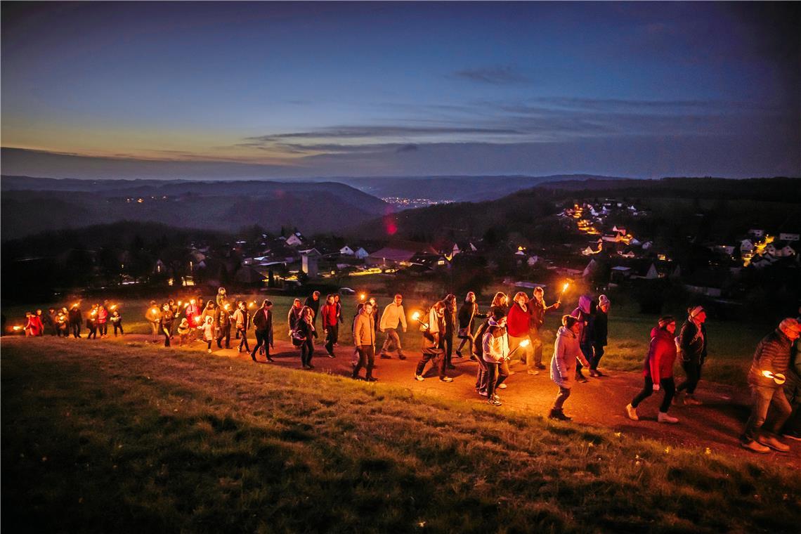 In Spiegelberg-Jux wandern die Besucherinnen und Besucher in der Dämmerung mit Fackeln hinauf zum Juxkopf. Foto: Alexander Becher