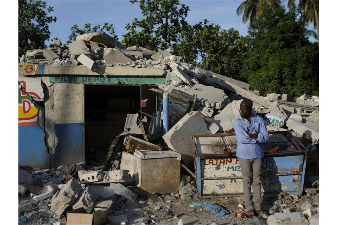 In Trümmern: Ein Mann steht vor einem eingestürzten Geschäft in Saint-Louis-du-Sud. Foto: Matias Delacroix/AP/dpa
