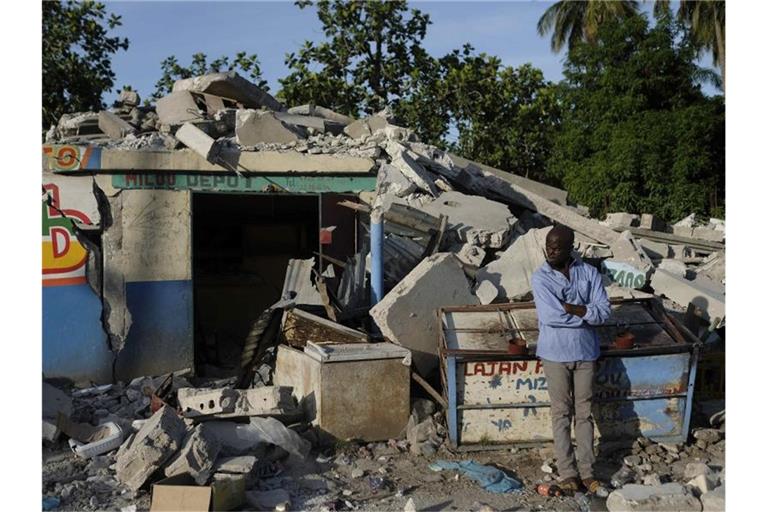In Trümmern: Ein Mann steht vor einem eingestürzten Geschäft in Saint-Louis-du-Sud. Foto: Matias Delacroix/AP/dpa