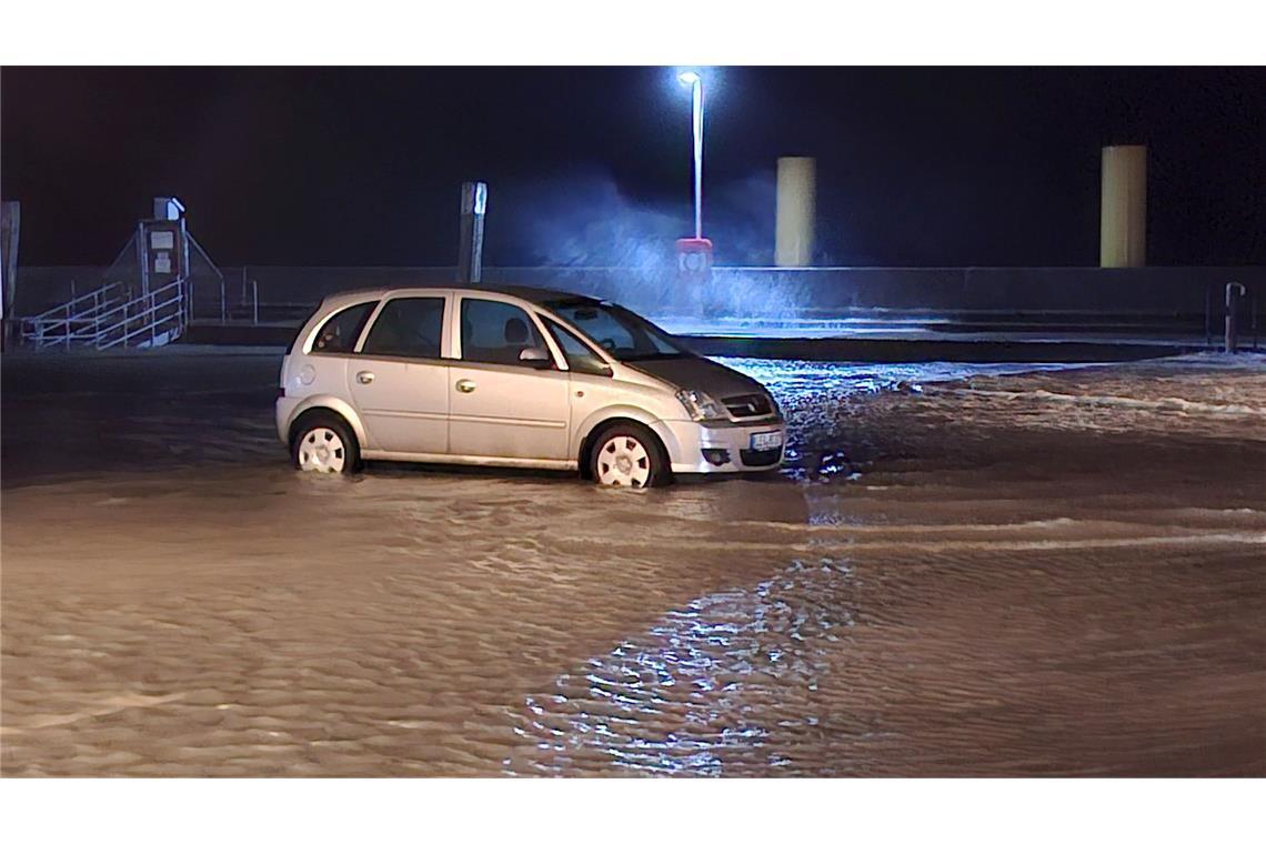 In Wilhelmshaven steht ein Auto auf einem überfluteten Parkplatz.