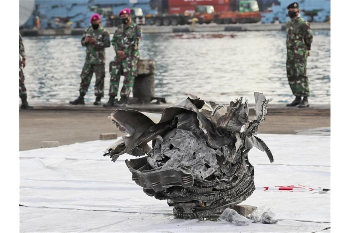 Schwierige Bergungsarbeiten nach Flugzeugabsturz vor Java Indonesische Marinesoldaten betrachten ein großes Teil des abgestürzten Flugzeugs der Sriwijaya Air. Foto: Tatan Syuflana/AP/dpa