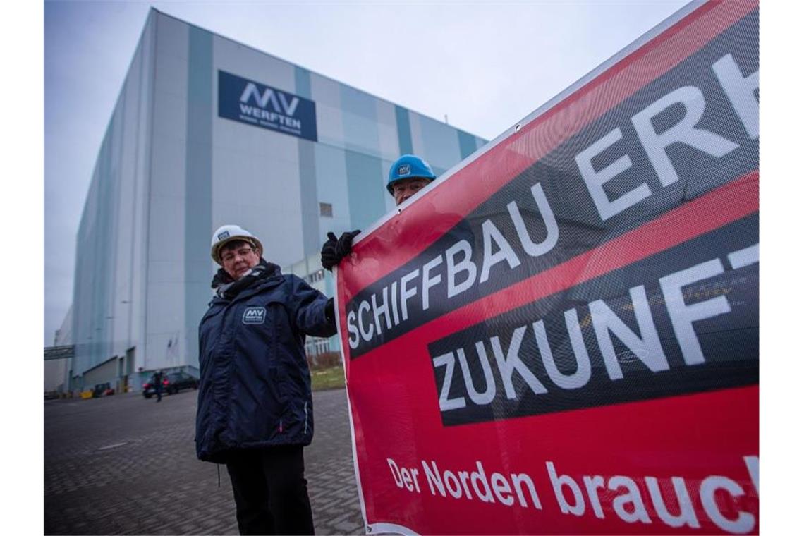 MV Werften und Lloyd-Werft insolvent - Hohes Ausfallrisiko Ines Scheel, Betriebsrätin der MV-Werften, und Schiffbauer stehen mit einem Transparent der IG Metall am Haupteingang zur MV Werft in Wismar. Foto: Jens Büttner/dpa-Zentralbild/dpa