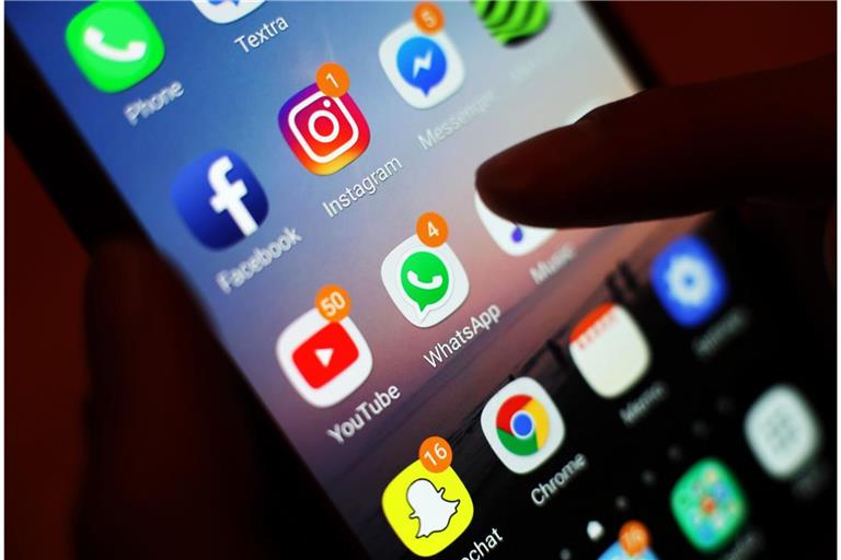 Influencer sind "dick" im Geschäft. Doch Steuern zahlen ist für einige ein No-go: Ein Smartphone-Display mit Symbolen von Social-Media-Apps, darunter Facebook, Instagram, YouTube und WhatsApp.
