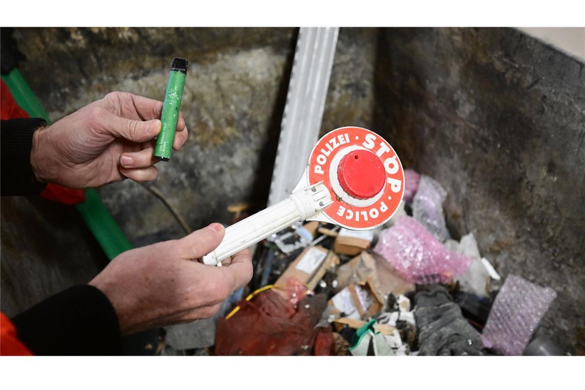 Inn einem  Recycling-Unternehmen in Albstadt zeigt ein Mitarbeiter ein Spielzeug und eine E-Zigarette mit einem Akku, das nicht für diese Abfallart vorgesehen ist und Brände verursachen kann.