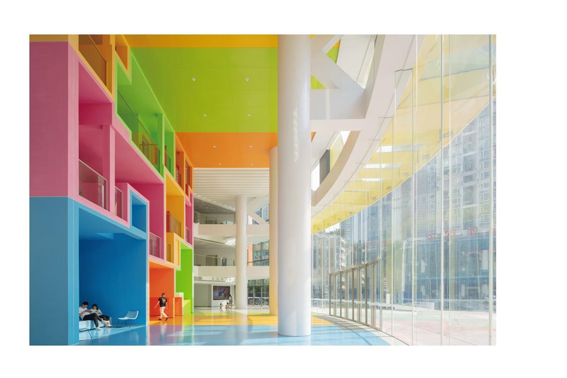 Das beste Hochhaus der Welt Innenansicht: Dort finden sich die Farben der Fassade wieder. Gelb, Orange, Rosa und Grün leiten die Besucher:innen durch das Gebäude und schaffen eine freundliche Atmosphäre.
