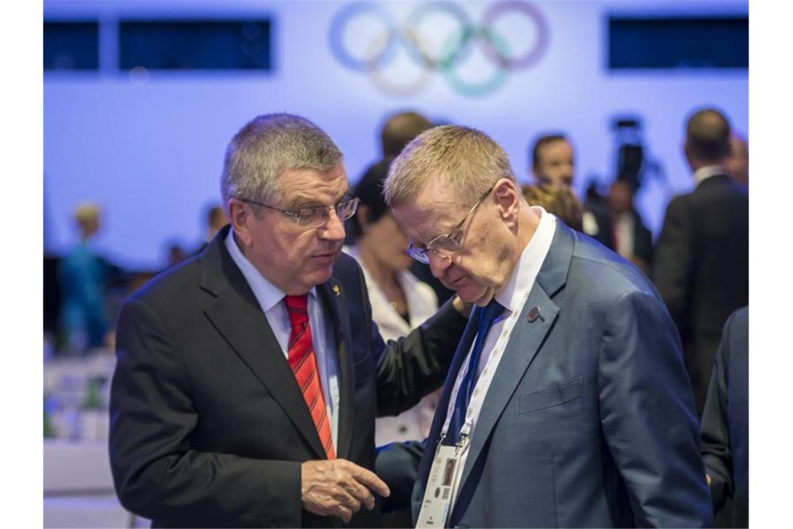 IOC-Präsident Thomas Bach (l) spricht mit John Coates, IOC-Mitglied aus Australien. Foto: Jean-Christophe Bott/KEYSTONE