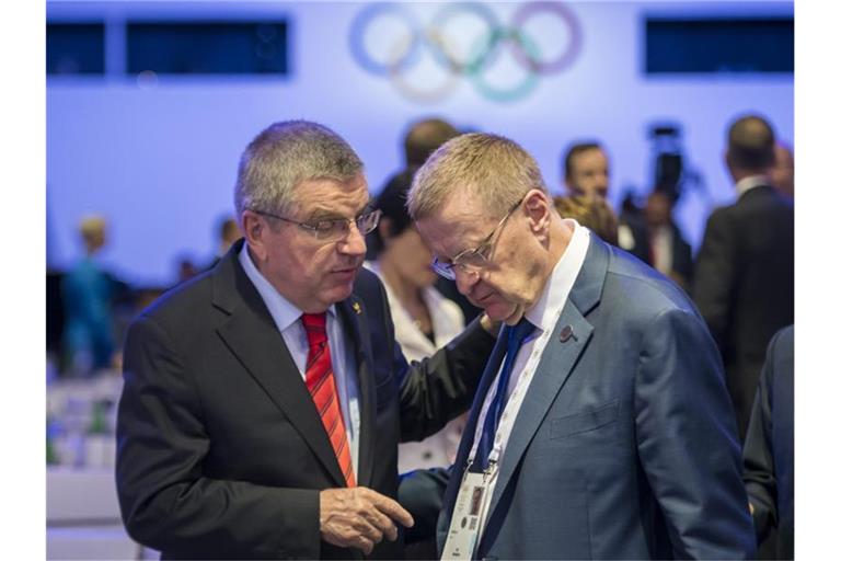 IOC-Präsident Thomas Bach (l) spricht mit John Coates, IOC-Mitglied aus Australien. Foto: Jean-Christophe Bott/KEYSTONE