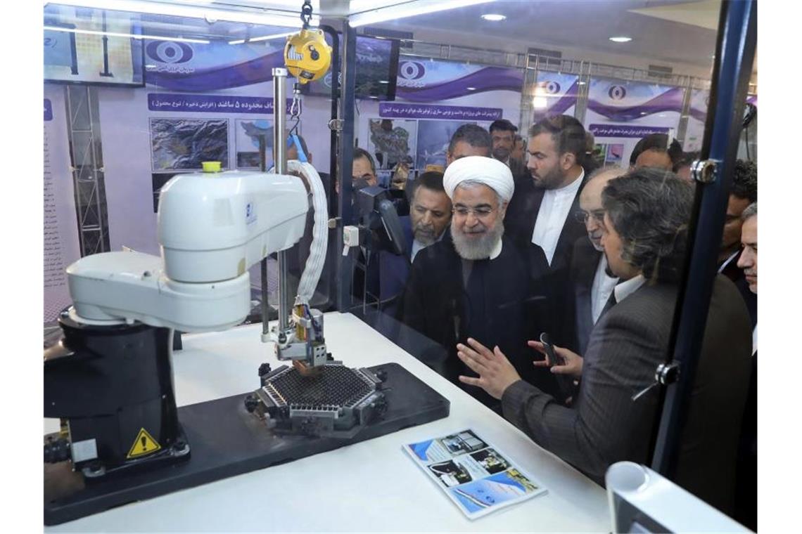 Iran informiert EU über Teilausstieg aus Atomdeal Irans Präsident Hassan Ruhani (M.) lässt sich neue Entwicklungen in der Atomenergie im Rahmen des „Nationalen Atomtags“ erklären. Foto: Iranian Presidency Office/AP
