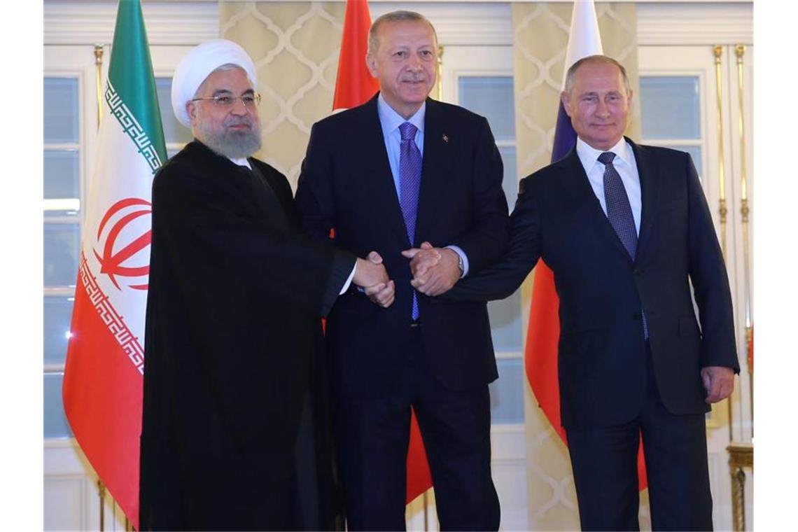 Syrien-Gipfel in Ankara - und keine Lösung für Idlib Irans Präsident Ruhani neben Gastgeber Erdogan und seinem russischen Amtskollegen Putin. Foto: arman/Iranian Presidency