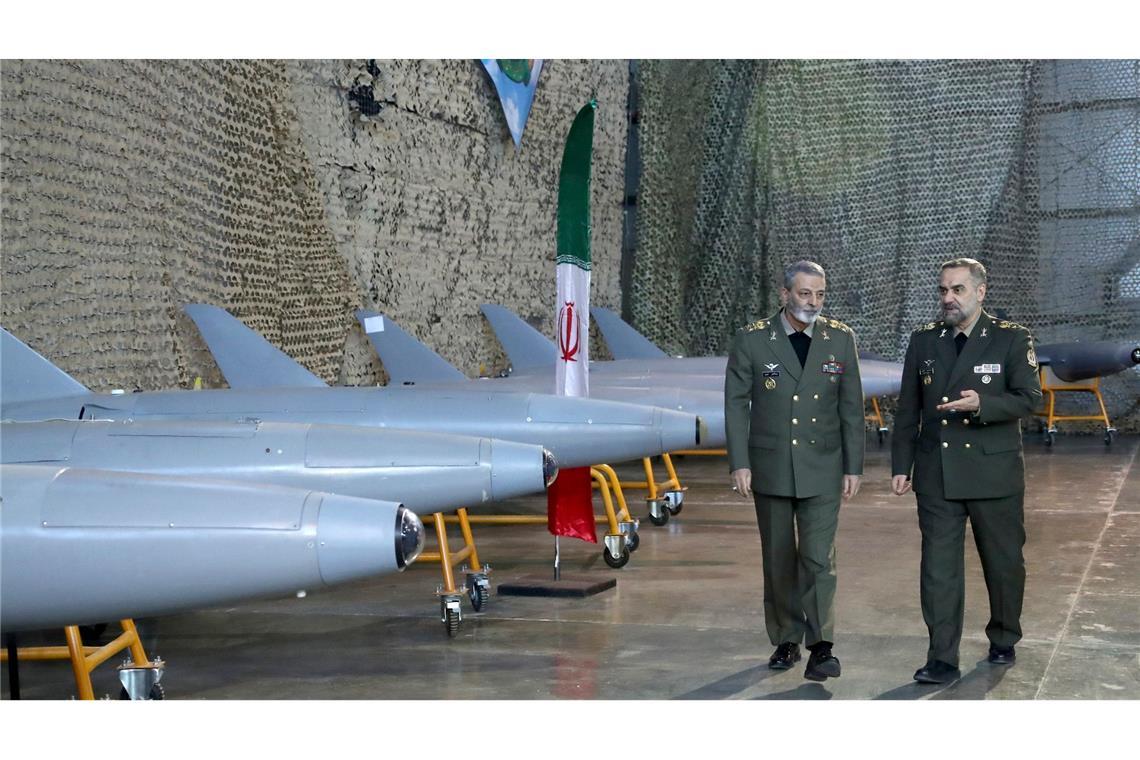 Irans Verteidigungsminister General Mohammed-Resa Aschtiani (r)spricht mit dem Befehlshaber der Armee, General Abdolrahim Mussawi, während einer Zeremonie zur Übergabe der im Inland gebauten Drohnen an die Armee.