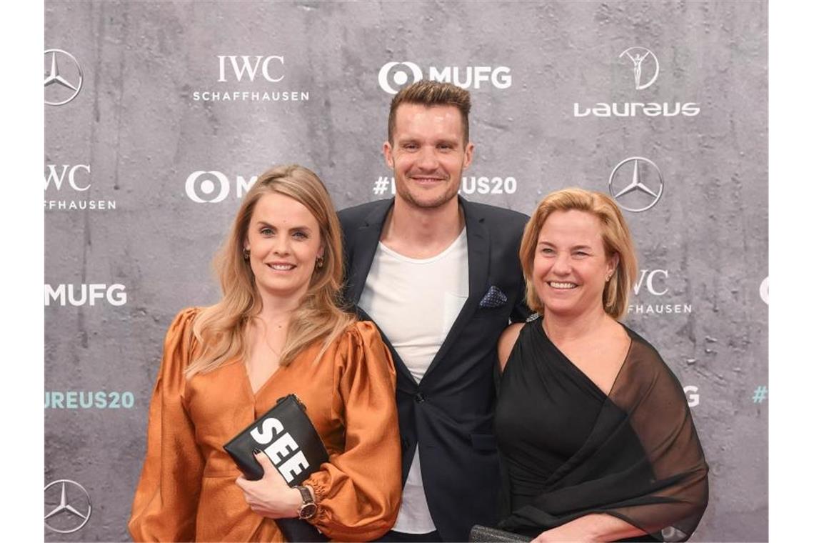 Ironman-Weltmeister Jan Frodeno kam mit Ehefrau Emma (l) und Mutter Christa in die Verti Music Hall. Foto: Jörg Carstensen/dpa