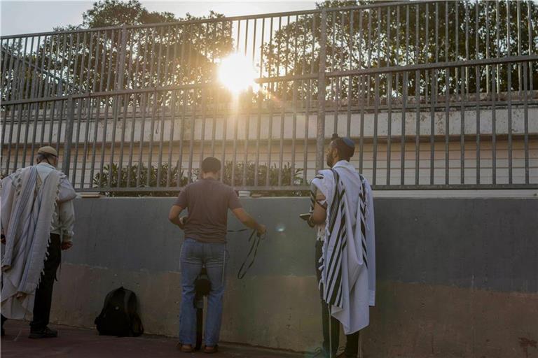 Israel, Tel Aviv: Menschen versammeln sich zum Gebet vor einem öffentlichen Luftschutzbunker.