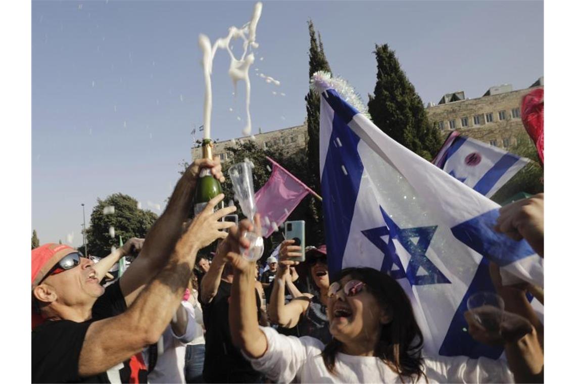 Knappe Parlamentsmehrheit für Israels neue Regierung Israelische Demonstranten feiern in Jerusalem das Ende der Amtszeit von Premier Netanjahu. Foto: Sebastian Scheiner/AP/dpa