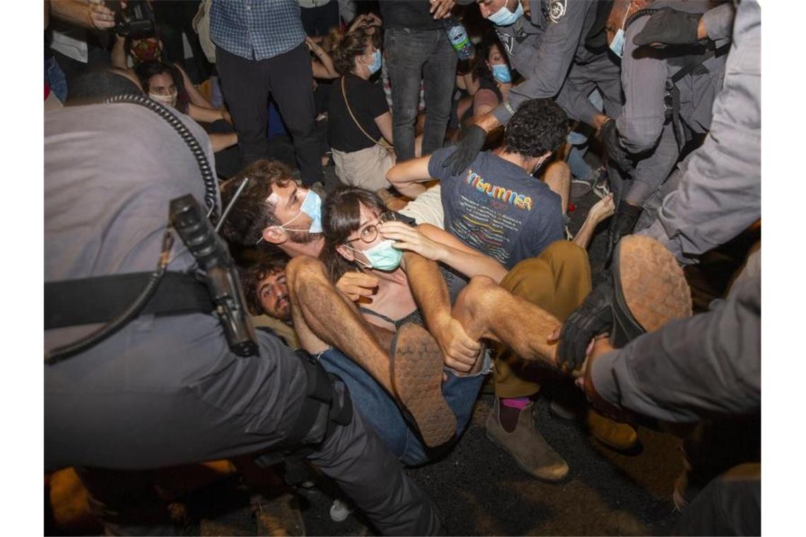 Israelische Polizeibeamte nehmen Demonstranten während eines Protests gegen Israels Premierminister Benjamin Netanjahu vor seiner Residenz in Jerusalem fest. Foto: Ariel Schalit/AP/dpa