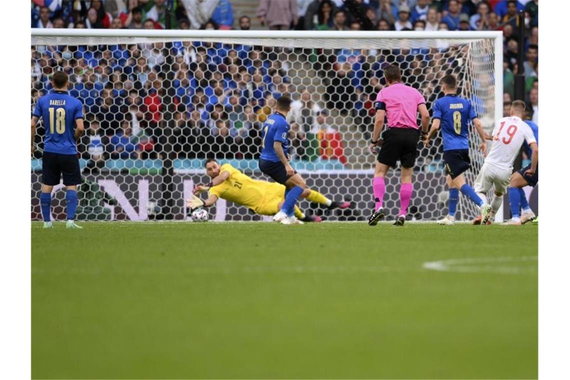Italien-Keeper Gianluigi Donnarumma pariert einen Schuss von Spaniens Dani Olmo (19). Foto: Laurence Griffiths/Pool Getty/AP/dpa