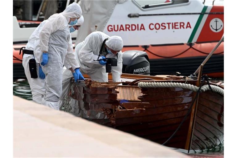 Italienische Forensiker begutachten den Schaden an einem Boot. Ein Motorboot, besetzt mit zwei Deutschen, hatte das kleine Boot eines italienischen Paares gerammt. (Archivbild). Foto: Gabriele Strada/AP/dpa