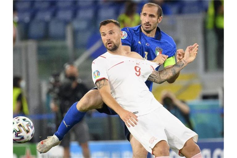 Italiens Giorgio Chiellini (r) im Zweikampf mit dem Schweizer Haris Seferovic. Foto: Jean-Christophe Bott/KEYSTONE/dpa