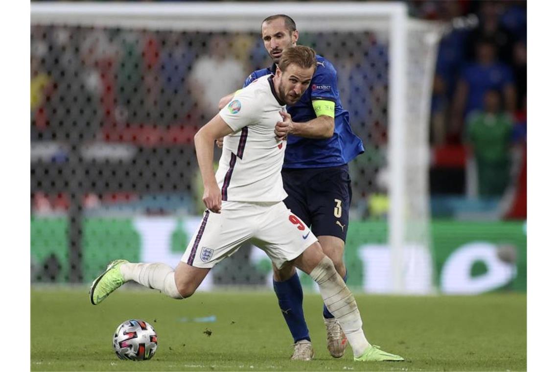 Italiens Giorgio Chiellini (r) kämpft mit Englands Harry Kane um den Ballbesitz. Foto: Carl Recine/Pool Reuters/AP/dpa