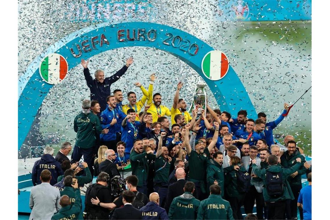 Italiens Spieler feiern nach dem Spiel mit dem Pokal die Europameisterschaft. Foto: Christian Charisius/dpa
