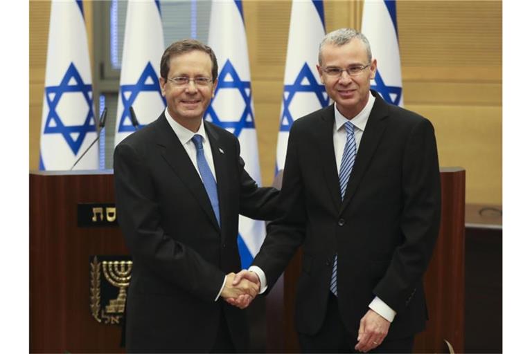 Izchak Herzog (l) gibt Knesset-Präsident Jariv Levin vor einer Sondersitzung die Hand. Israels Parlament hat den früheren Oppositionsführer zum Staatspräsidenten gewählt. Foto: Ronen Zvulun/Pool Reuters/AP/dpa