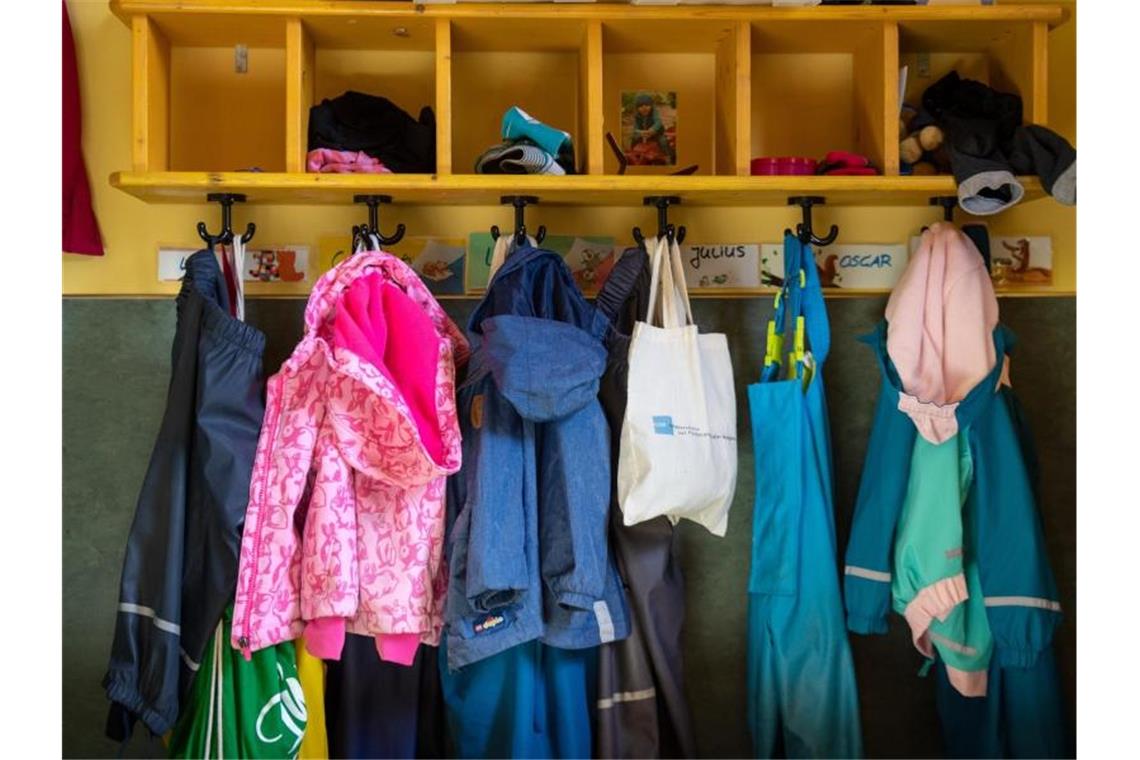 Kitas und Eltern fordern Rückkehr zum Normalbetrieb Jacken und Taschen hängen im Eingangsbereich in einem Kindergarten. Foto: Monika Skolimowska/dpa-ZB/Symbolbild/Archiv