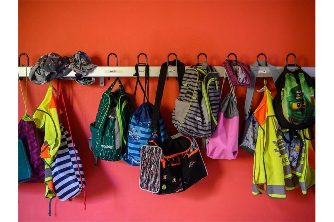 Jacken und Taschen hängen in einer Grundschule an einer Garderobe. Foto: Sebastian Gollnow/Archivbild
